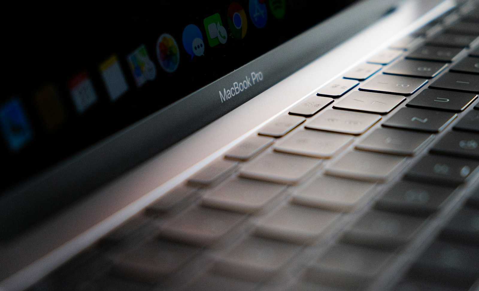 Close view of a MacBook Pro keyboard and Touch Bar with macOS dock icons