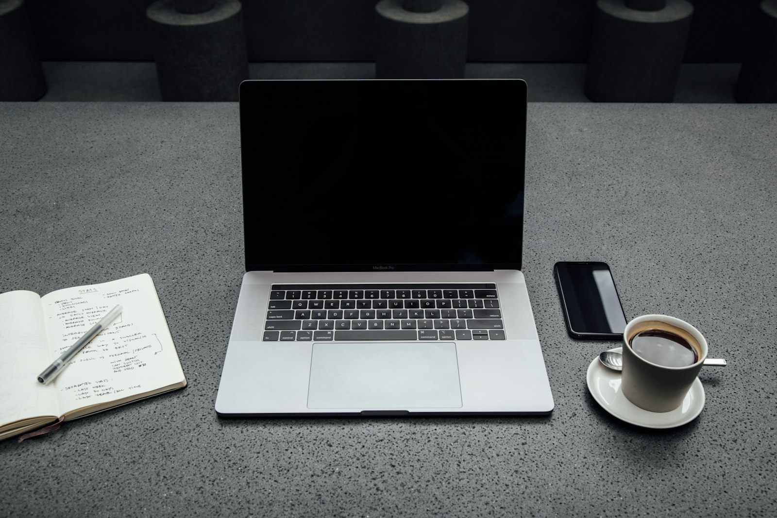 Silver laptop with a lit screen on a wooden table